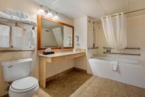 A bathroom with a toilet, sink, mirror, shower, and bathtub.