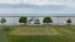 A marina with boats docked, a grassy area, and a view of the water.