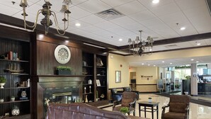 A lobby with a fireplace, leather sofas, and a reception area.