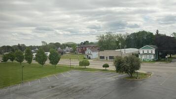 A parking lot with multiple parking spaces and a grassy area with trees.