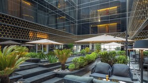 Un espace extérieur moderne aménagé avec des terrasses en gradins, du mobilier d’extérieur et une végétation luxuriante.