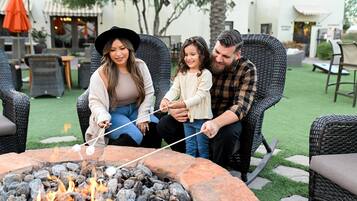 A family enjoying a fire pit with a marshmallow-roasting activity.