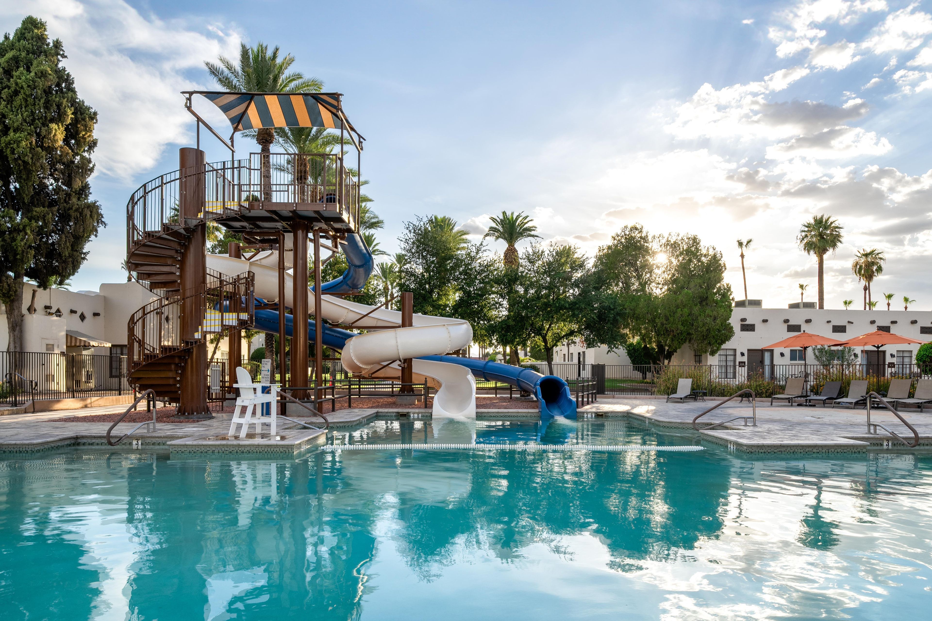 A pool with a water slide and a children's play area.