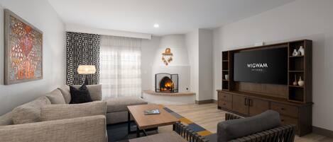 Een moderne woonkamer met een open haard, een televisie en een bank.