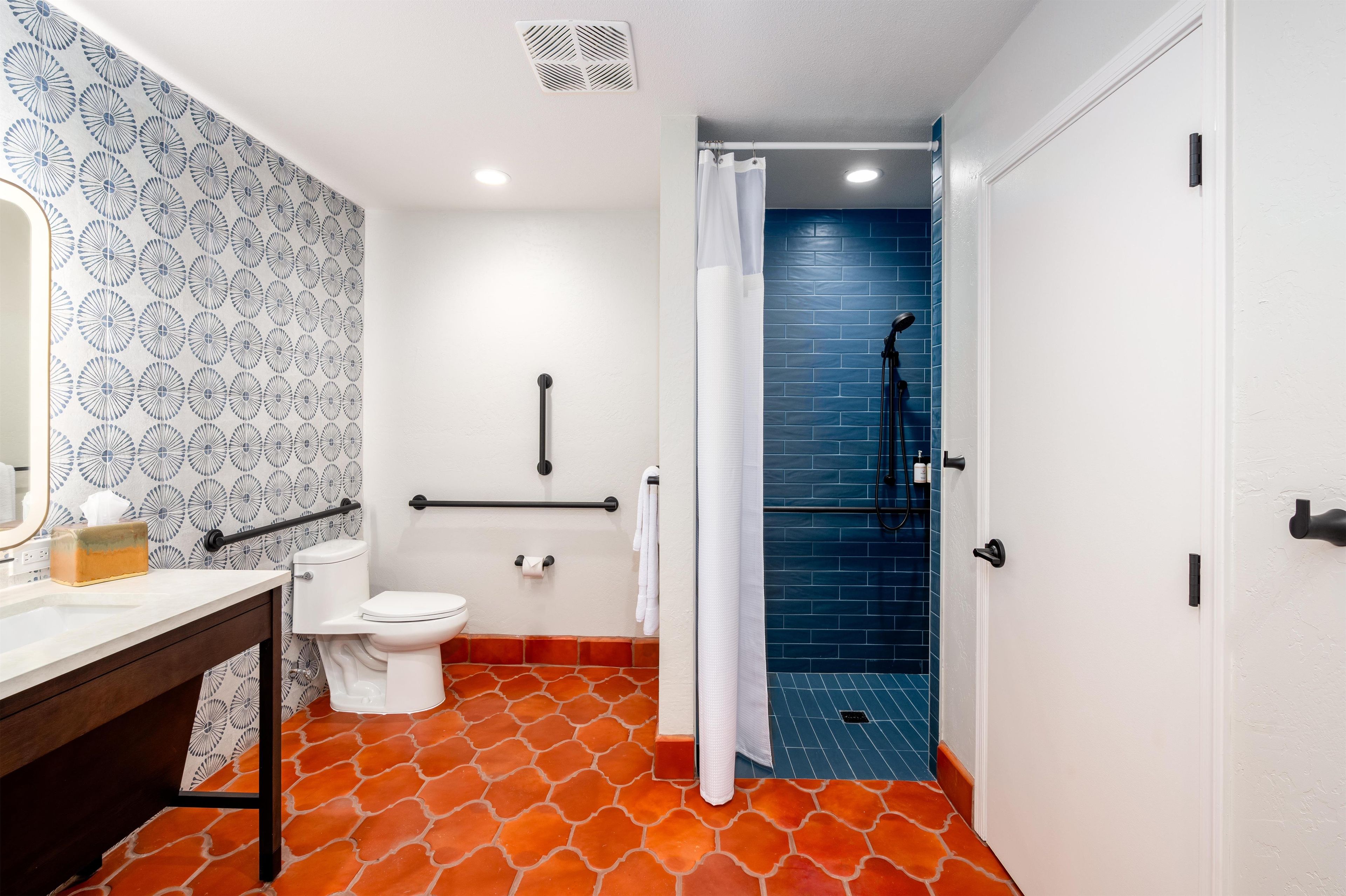 Ein Badezimmer mit Toilette, Waschbecken und Duschbereich.