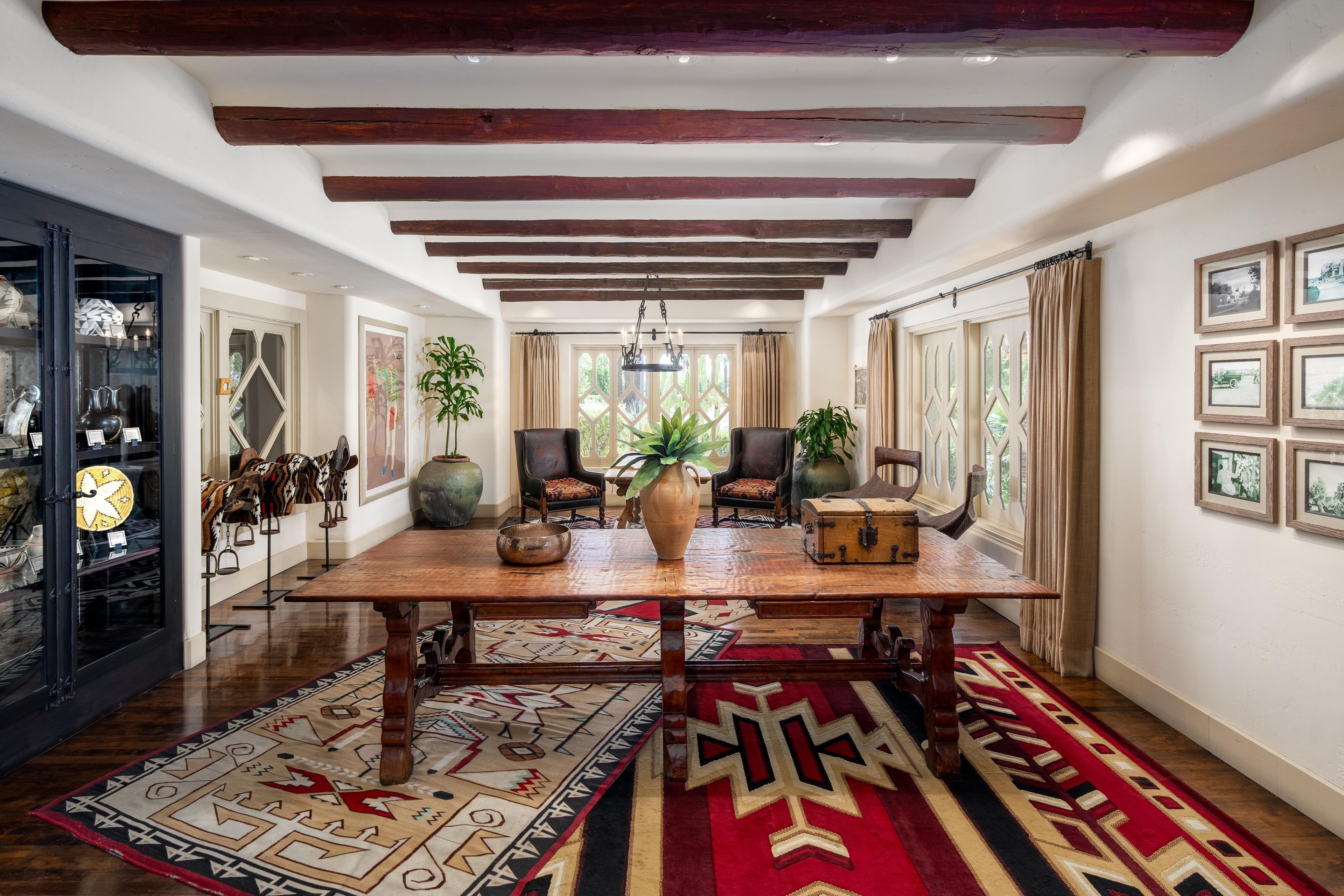 A spacious room with a wooden table, chairs, and a large vase.