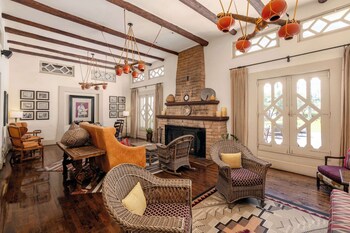A desert-style building with a patio area, surrounded by cacti and palm trees. at The Wigwam