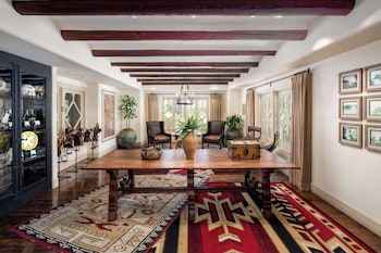 Relax in a stylishly furnished room with a high ceiling, large dining table, and comfortable seating. at The Wigwam