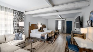 Una habitación de hotel con cama, sofá, escritorio y televisor.