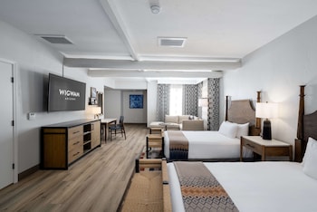 Relax in a spacious room with a large bed, flat-screen TV, and comfortable seating area. at The Wigwam