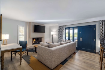 Relax in this stylish living room with a large sofa, dining table, and flat-screen TV. at The Wigwam