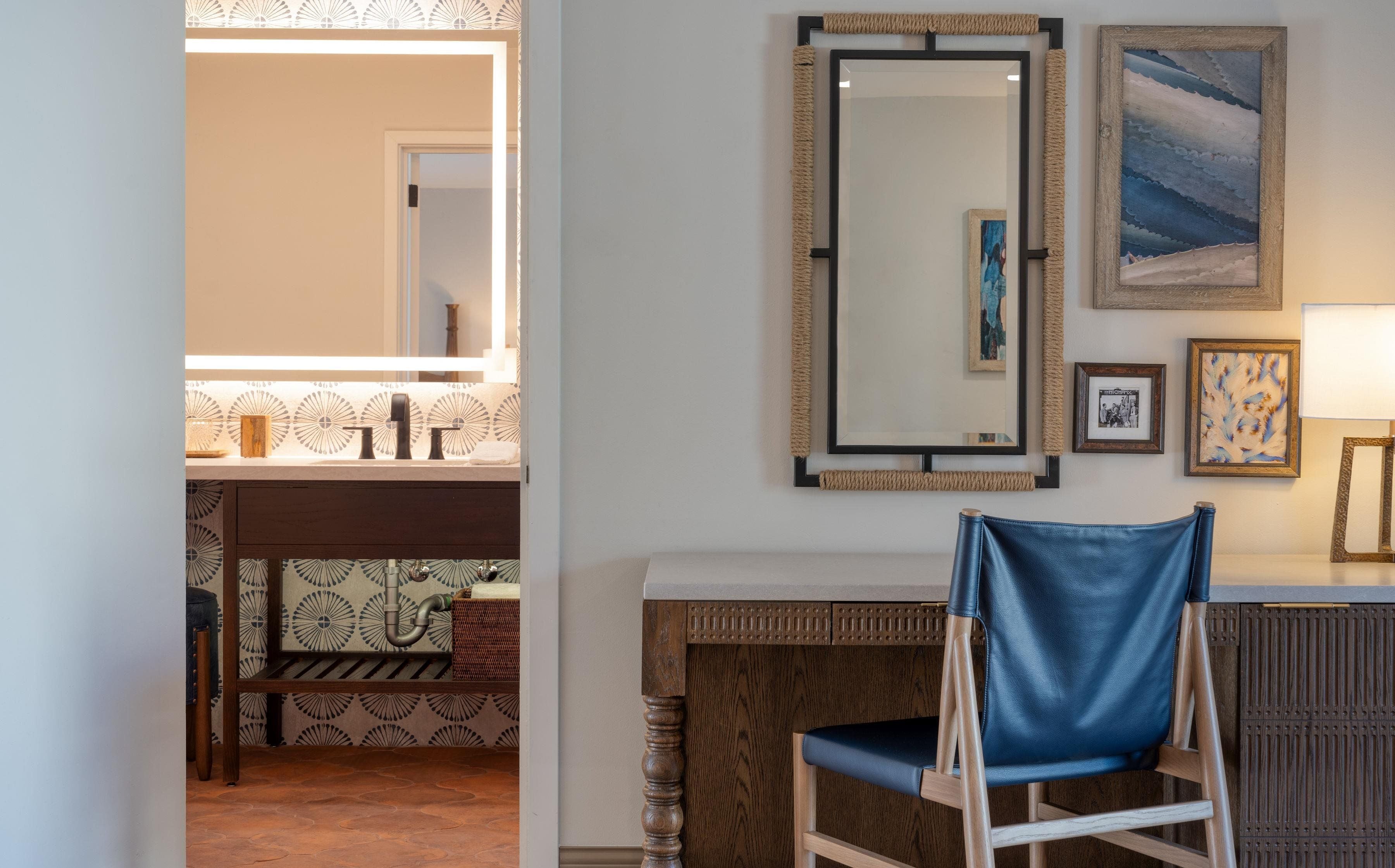 A bathroom with a mirror, sink, and patterned tiles.