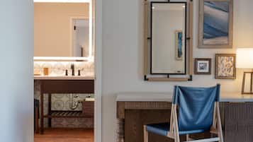 A bathroom with a mirror, sink, and patterned tiles.