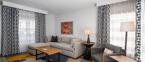Uma sala de estar moderna com um sofá, mesa de centro e uma luminária.