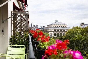 Un balcone con piante in vaso e vista su un edificio storico.
