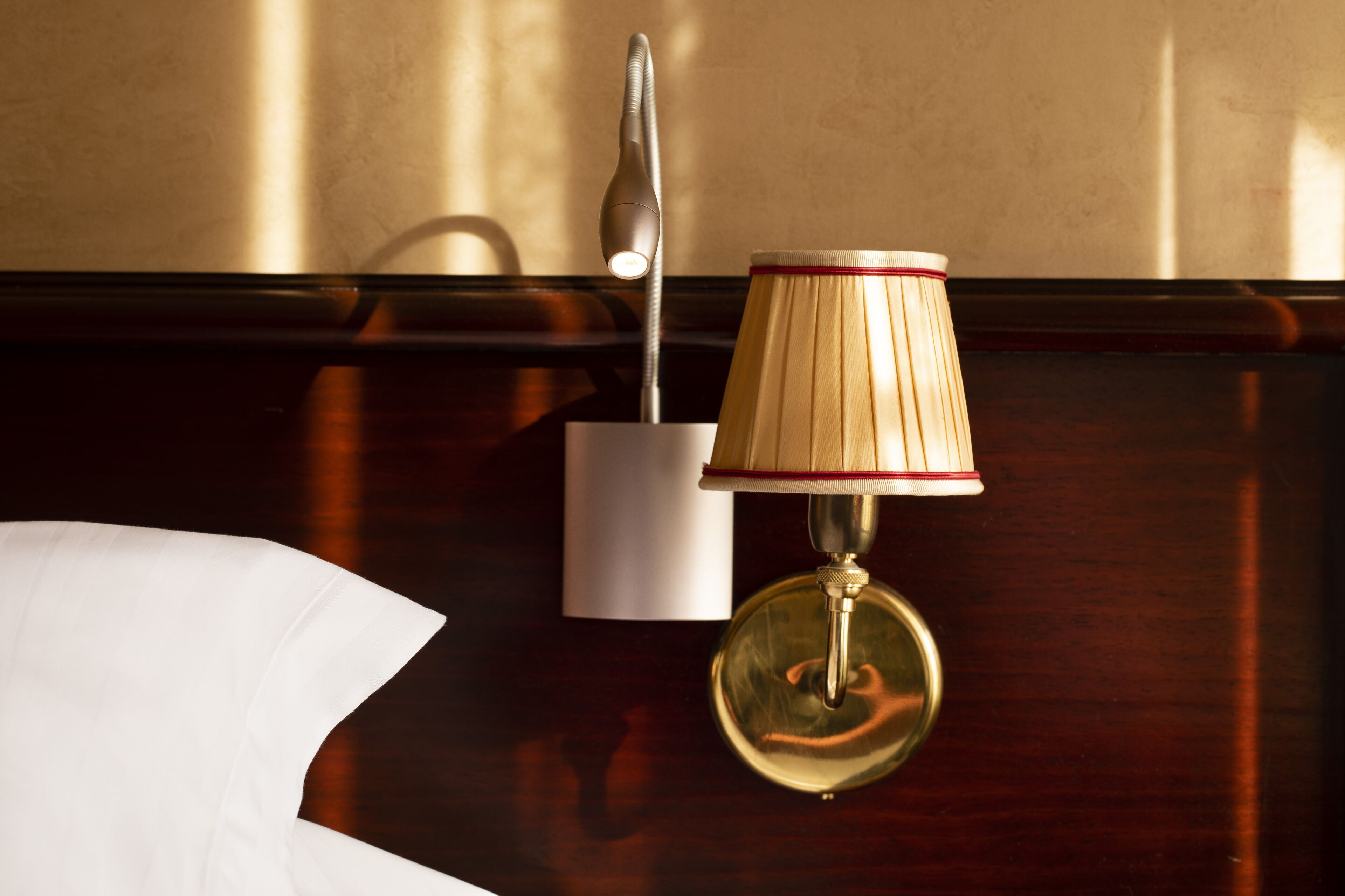 Et slejlet træbord med en lampe og et hvidt objekt, muligvis en menu eller et kort, på bordet.