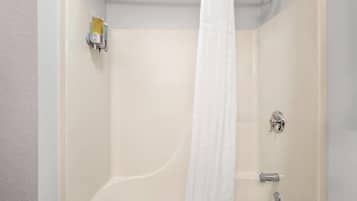Un baño con bañera, cortina de ducha, toallero y dispensador de jabón.