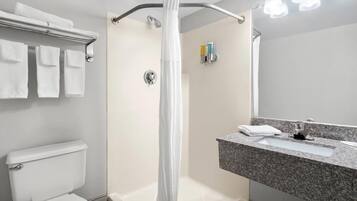 A modern bathroom with a shower, toilet, and sink.