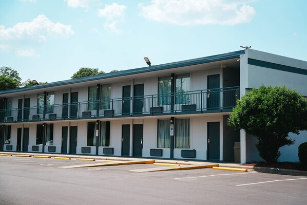 A motel with a two-story structure, multiple balconies, and a parking lot.