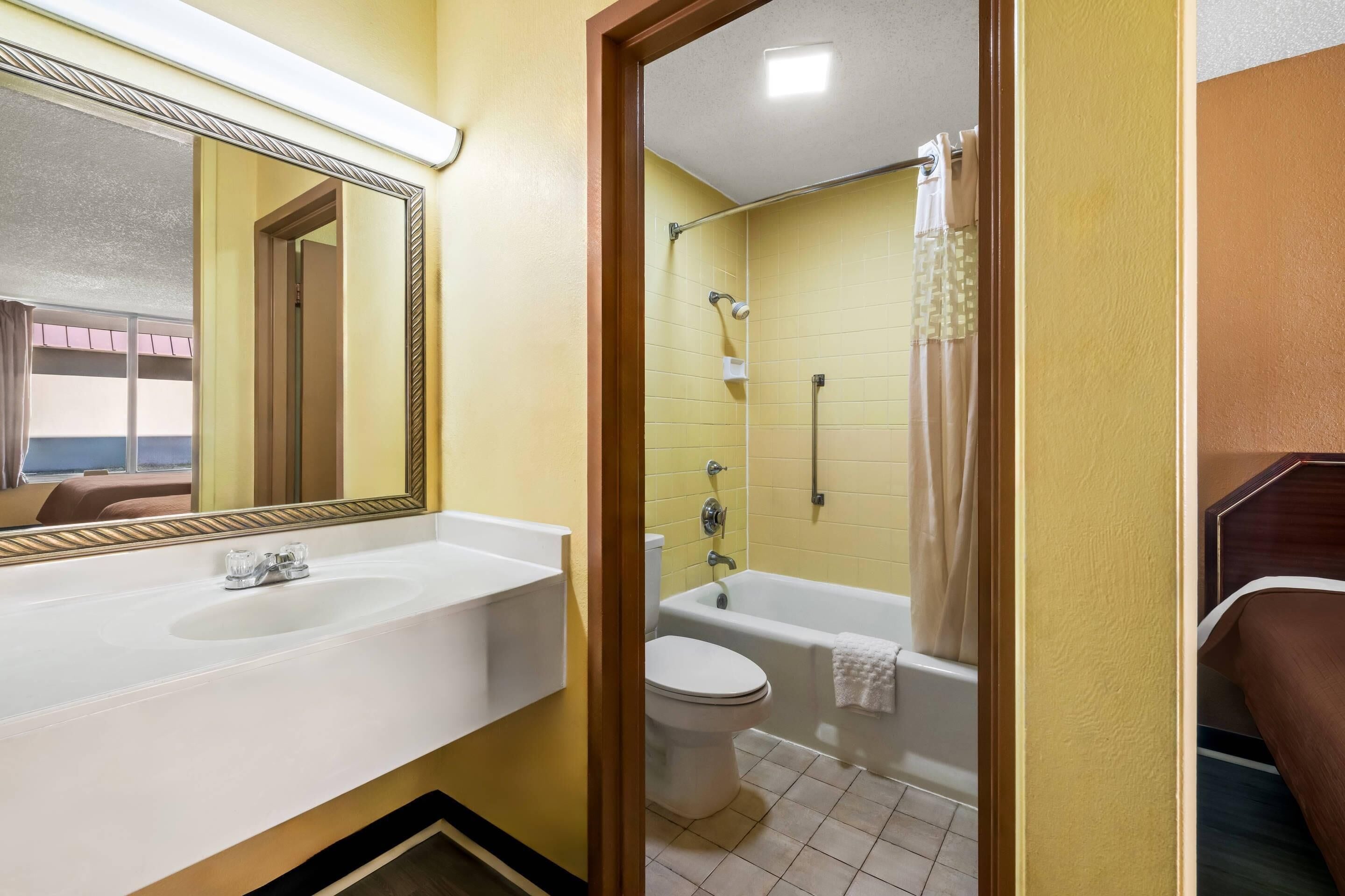 Een badkamer met een wastafel, toilet en bad.