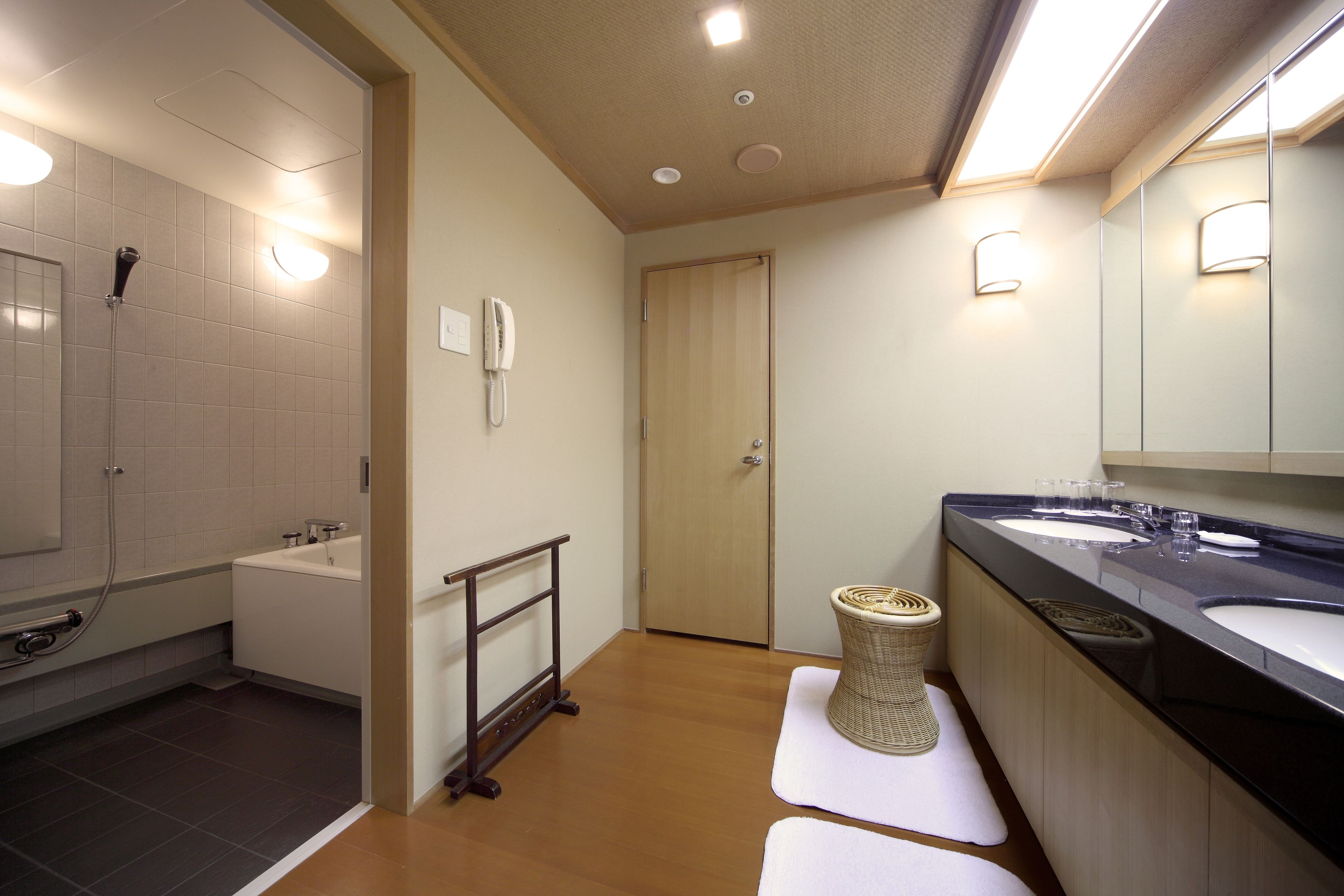 A modern bathroom with a bathtub, a shower, a toilet, and a sink.