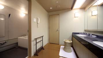 A modern bathroom with a bathtub, a shower, a toilet, and a sink.