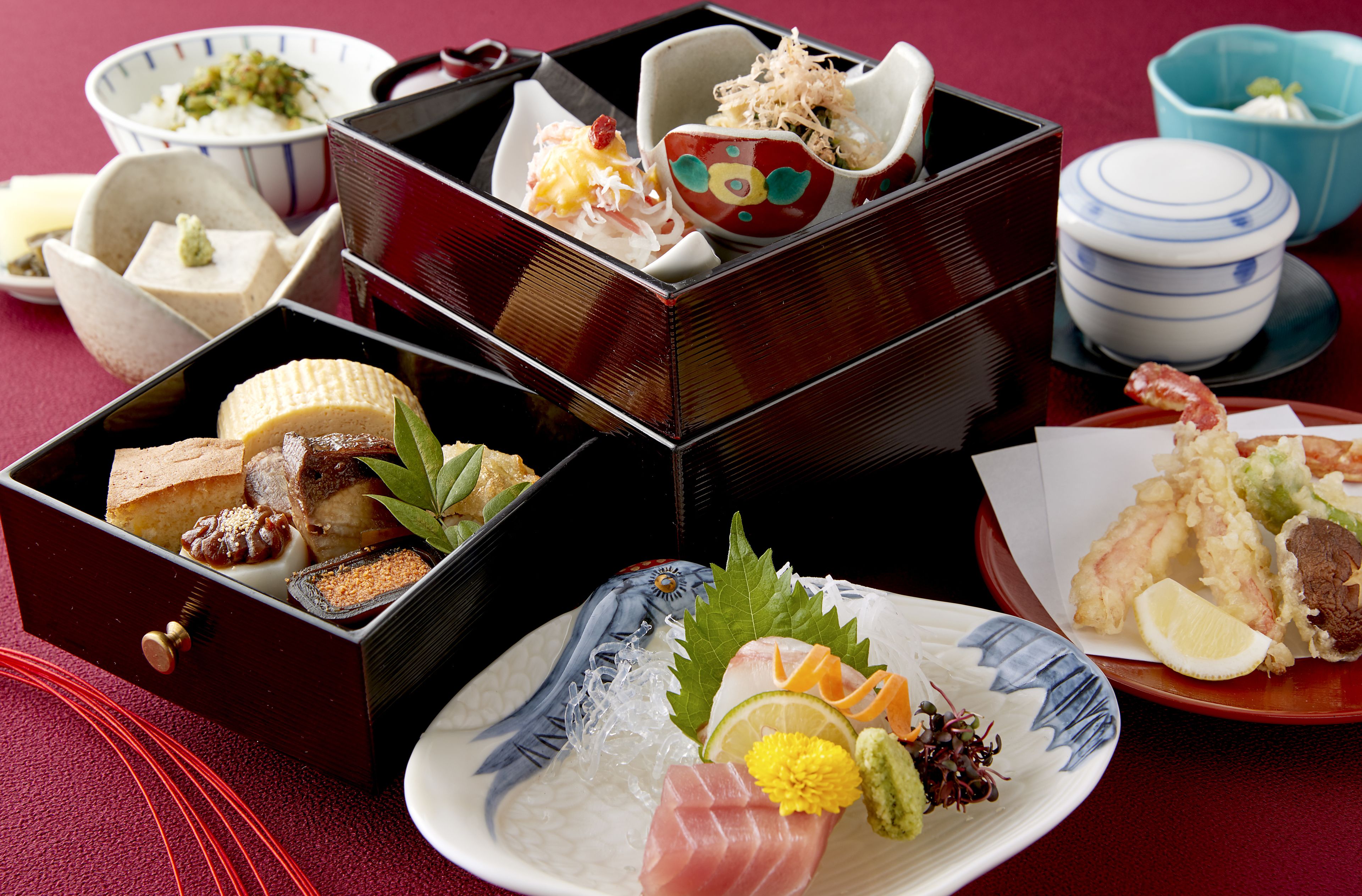 A traditional Japanese meal with various dishes in separate containers.