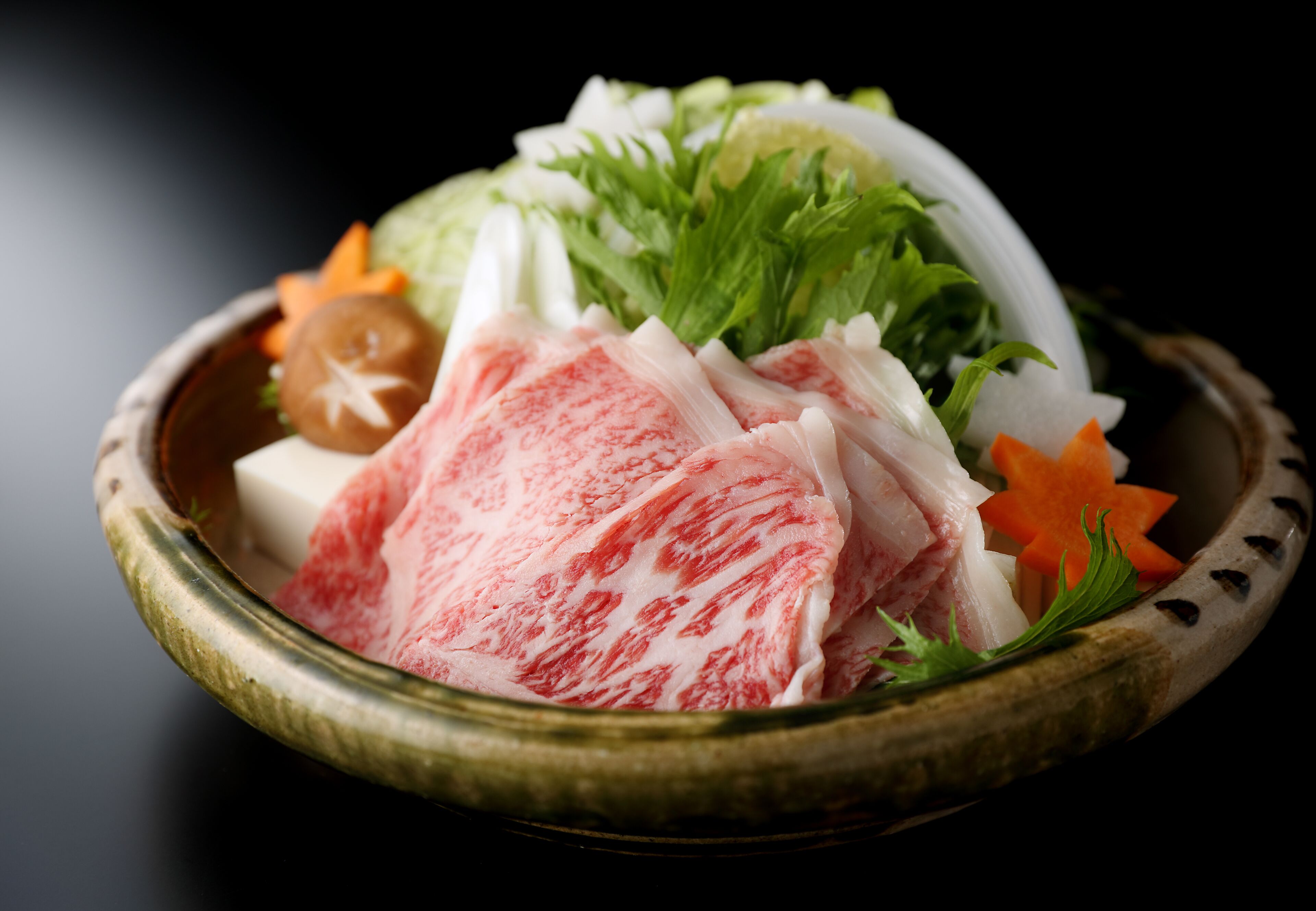 A bowl of sashimi with various garnishes.
