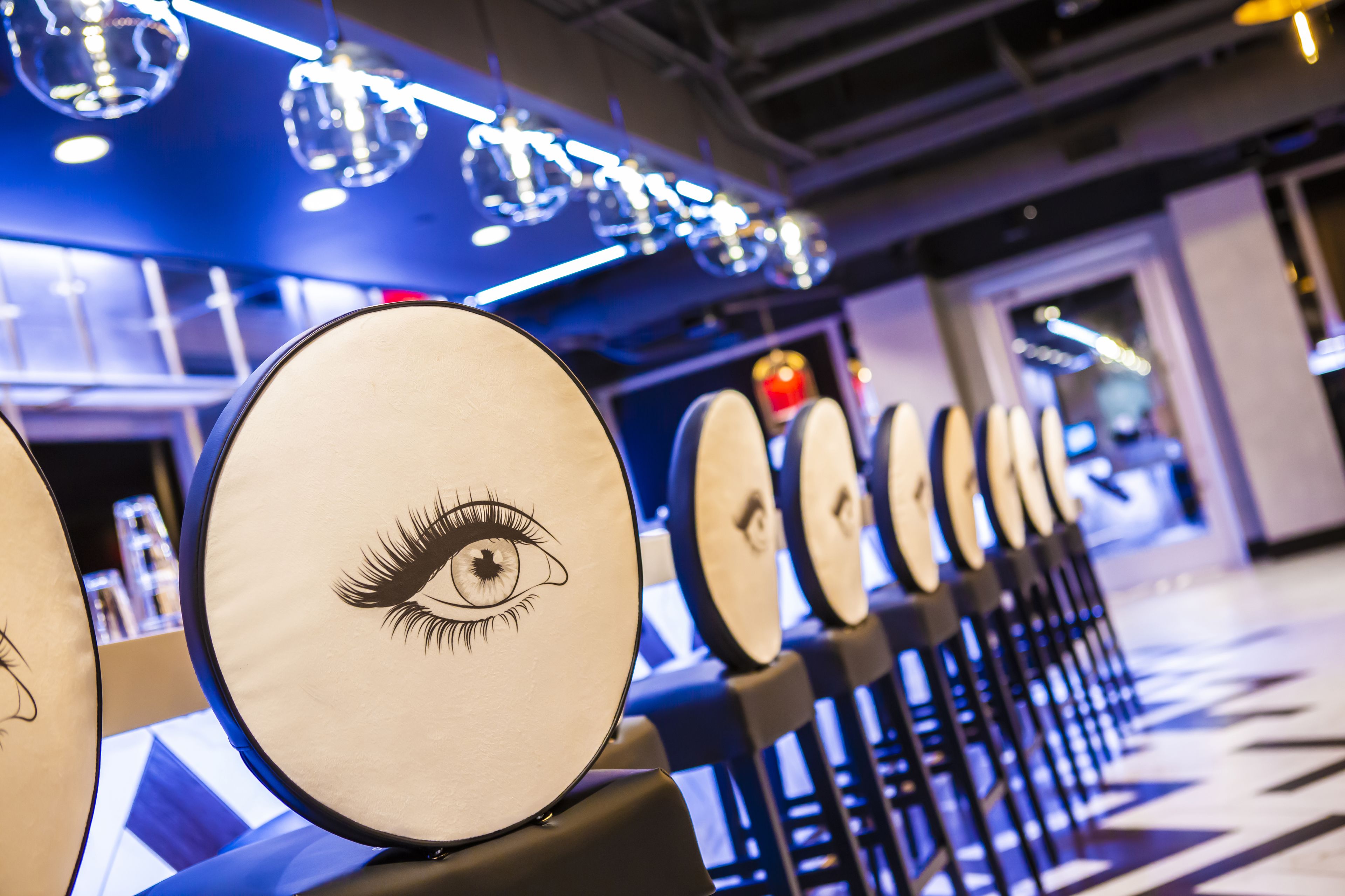 A row of drum sets with a drum head featuring an eye design.