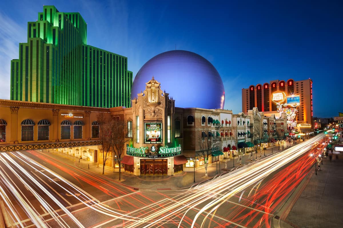 A historic building with a marquee sign, a large dome, and a casino sign in the background.