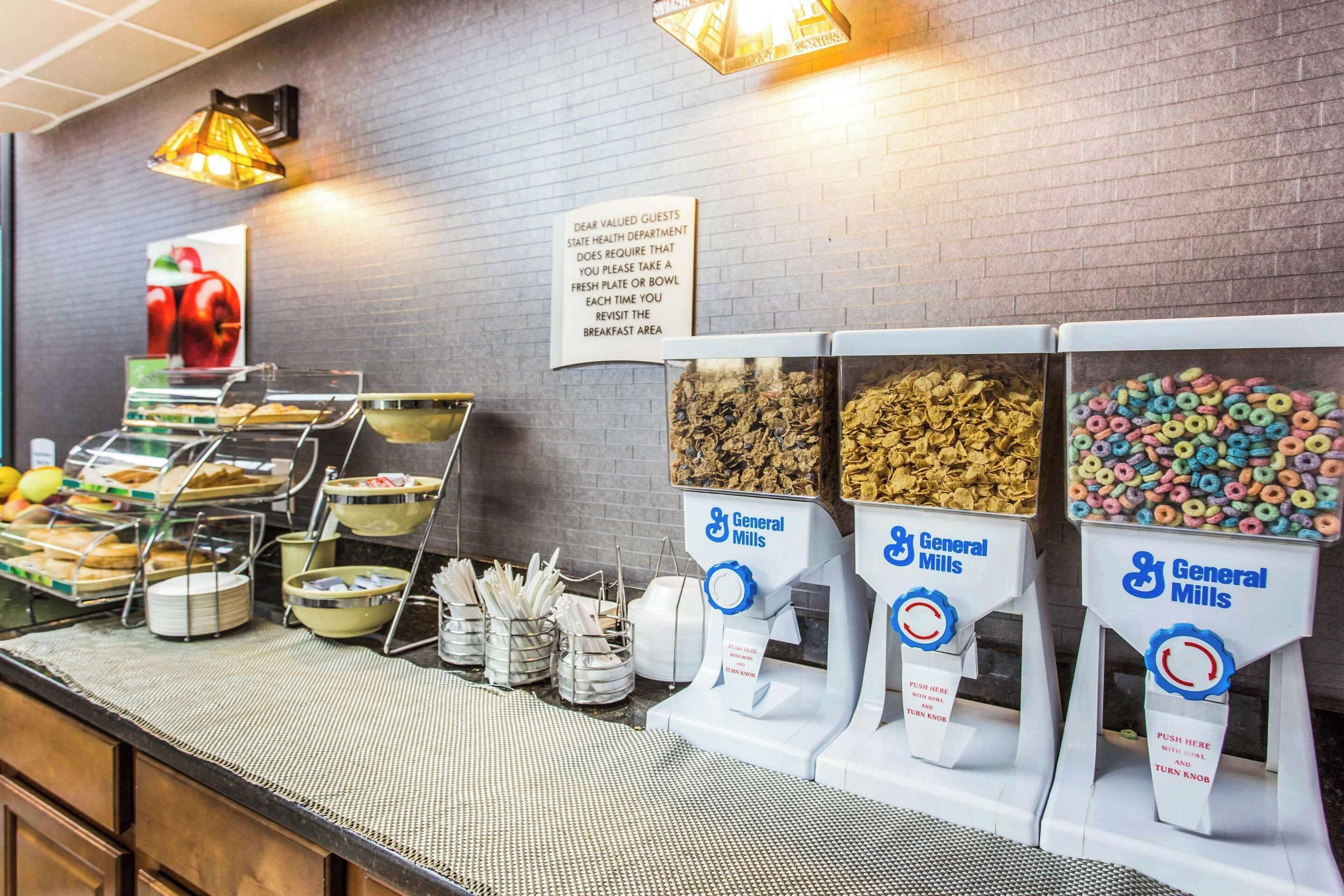 Un bufé de desayuno con diversas opciones de comida y dispensadores de cereales General Mills.