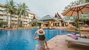 Relax by the pool, surrounded by traditional architecture and comfortable lounge seating.