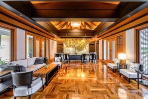 A spacious lobby with a wooden floor, seating area, and a reception desk. - Holiday Inn Resort Phuket by IHG (Patong)