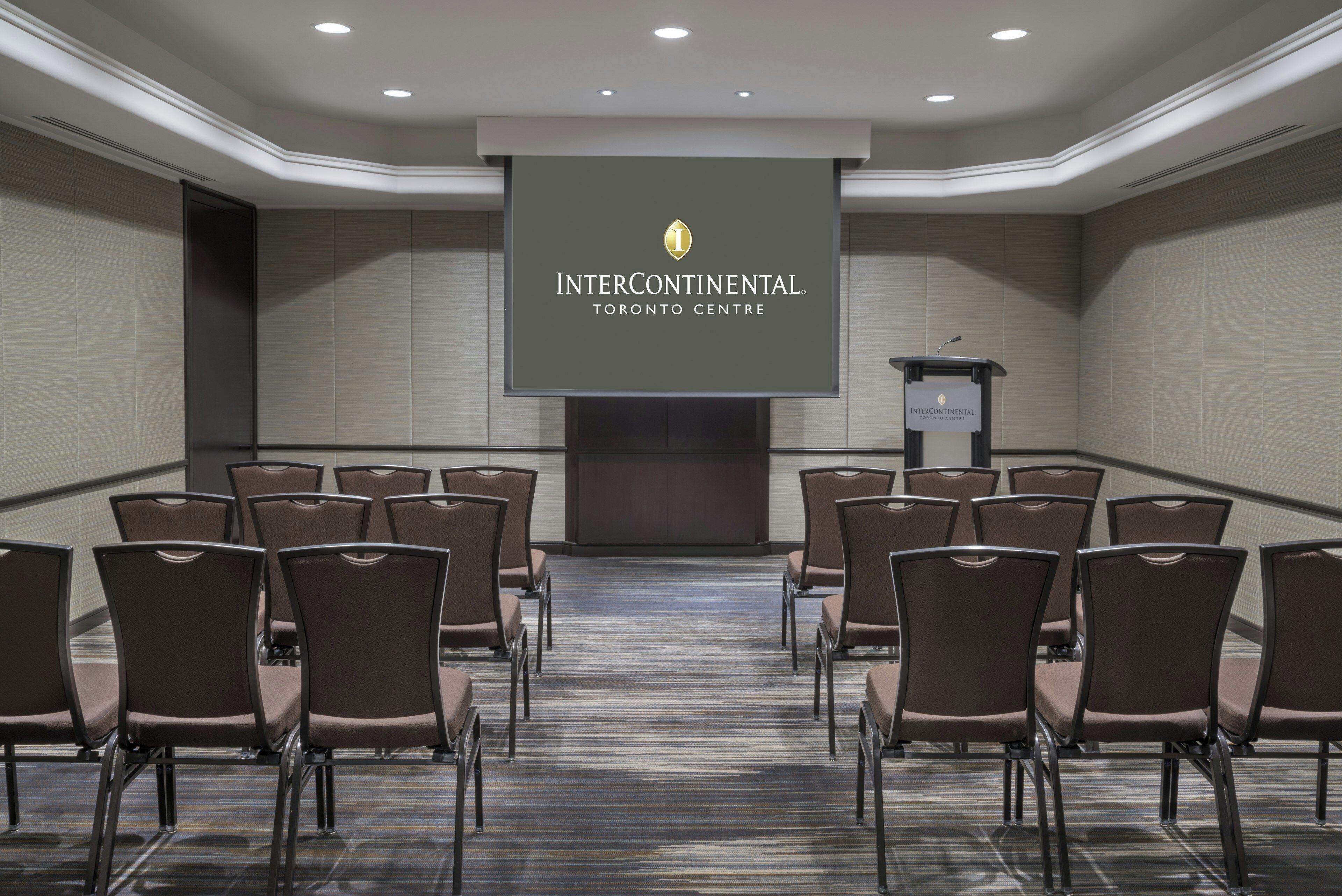 Un salón de conferencias con filas de sillas mirando hacia una pantalla de presentación en Intercontinental Toronto Centre.