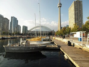 A marina with boats docked, a tall tower, and modern buildings in the background. - InterContinental Toronto Centre by IHG (Toronto)