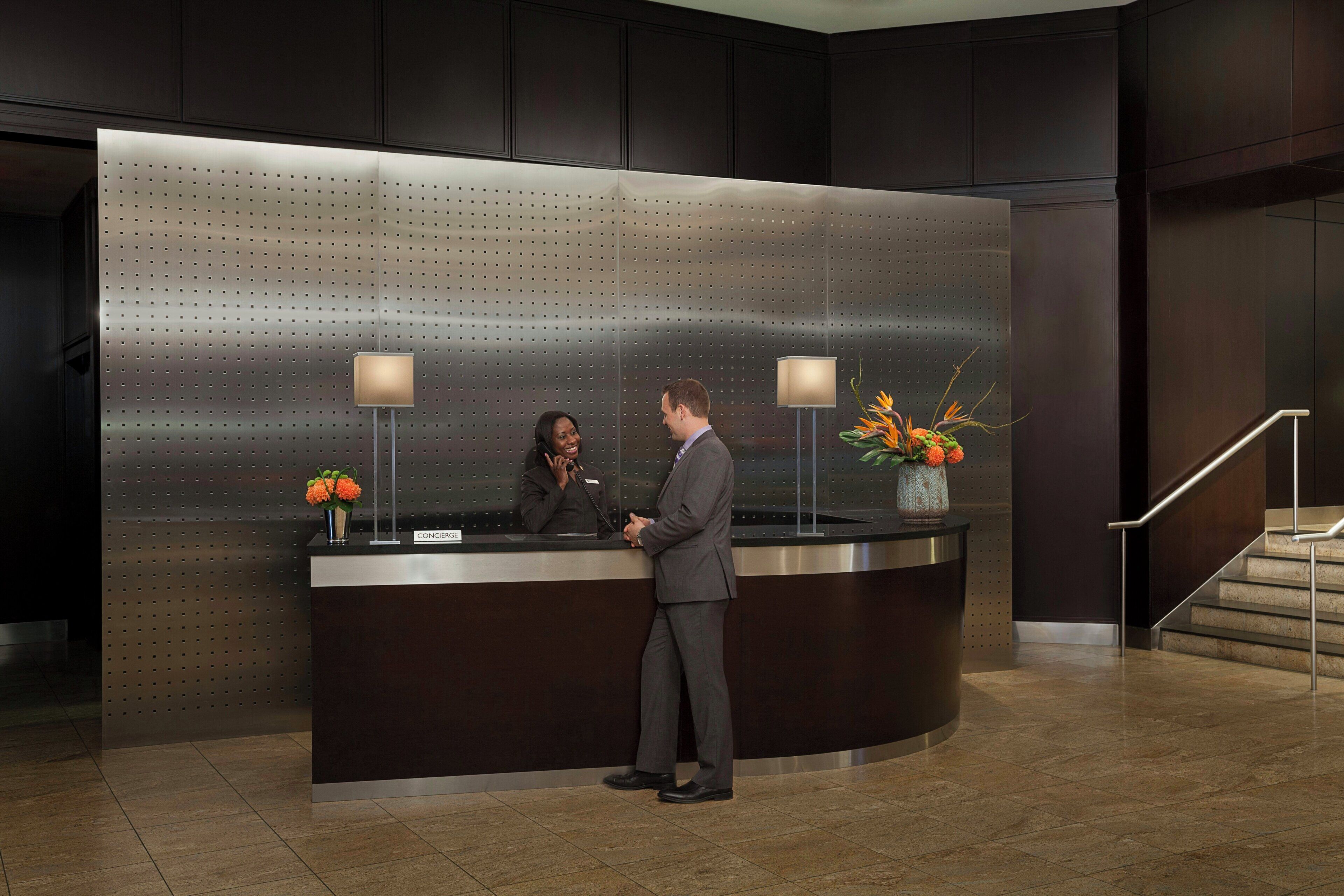 A reception desk with a modern design, a nameplate, and two lamps.