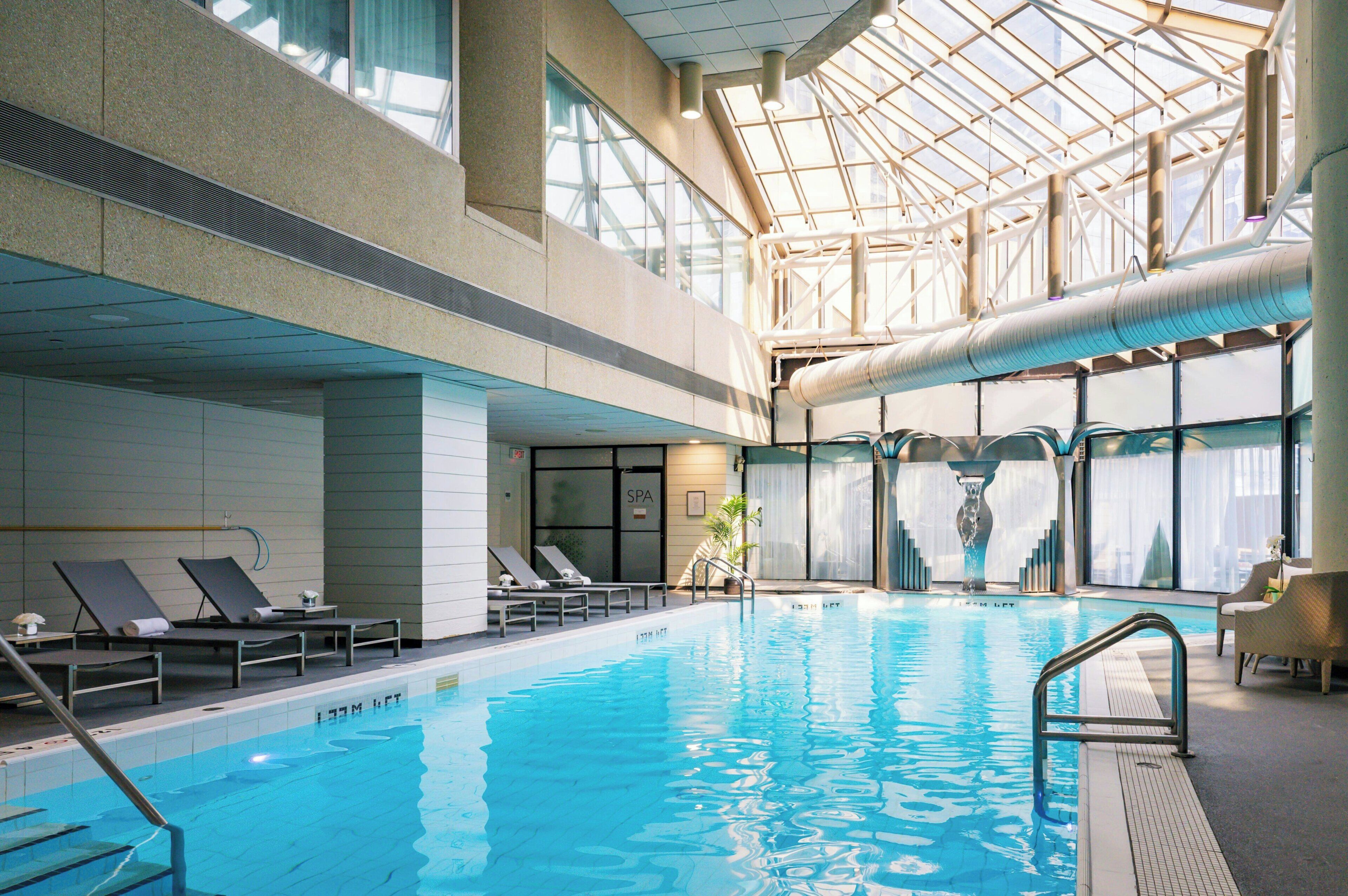 Ein Innenpool mit Liegestühlen und einem Wellnessbereich.