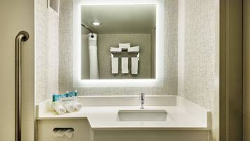 A bathroom with a white sink, a mirror, and a towel rack.