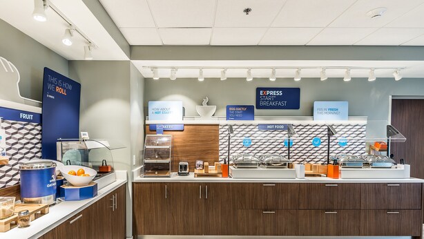 A modern breakfast bar with a variety of food options, including a fruit section and a hot food station. - Holiday Inn Express Flint-Campus Area by IHG (Flint)