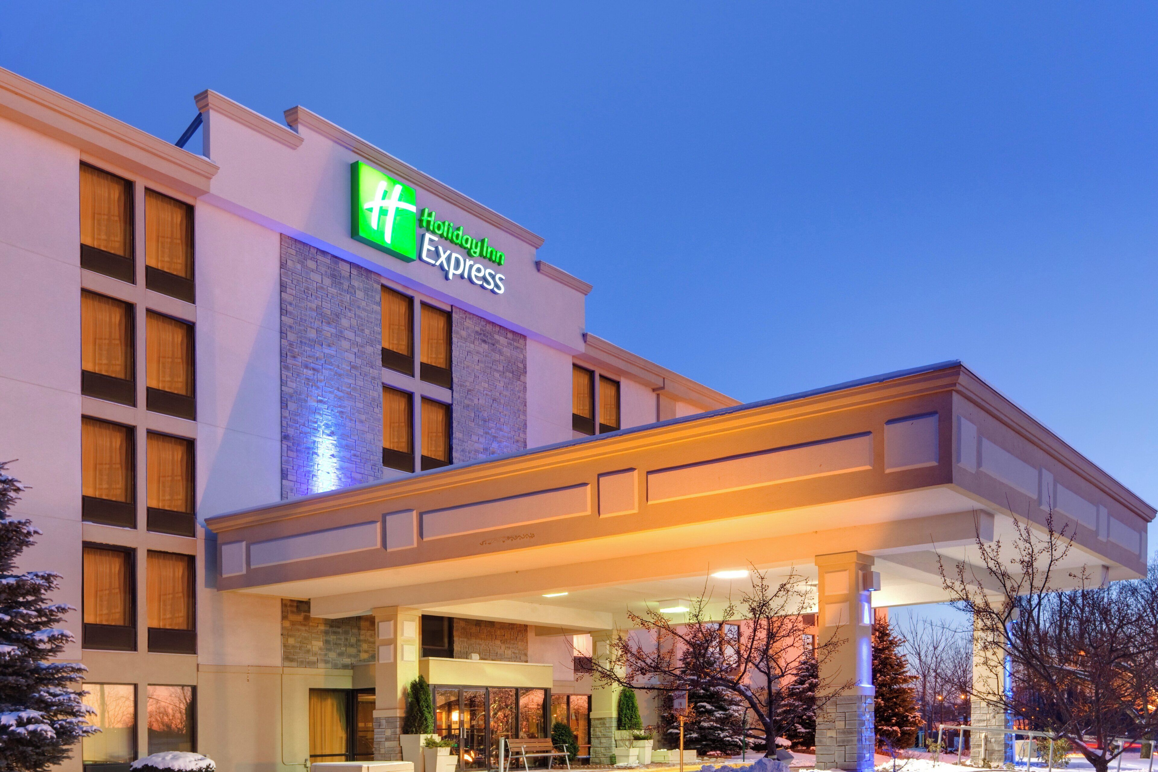 A Holiday Inn Express building with a covered entrance, large windows, and a brick facade.