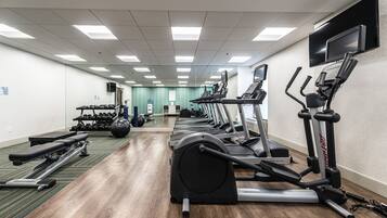 A gym with treadmills, elliptical machines, and weight equipment.
