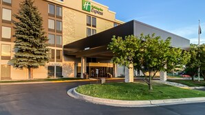 A Holiday Inn Express building with a modern design, featuring a large entrance canopy and a well-maintained lawn area. - Holiday Inn Express Flint-Campus Area by IHG (Flint)