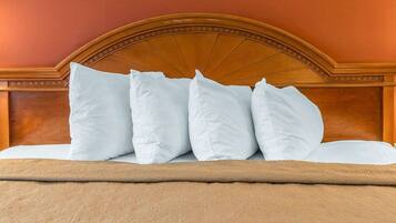 A bed with a headboard, multiple pillows, and a blanket.