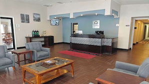 A hotel lobby with a reception desk, seating area, and a television screen. - Quality Inn Gaylord (Gaylord)