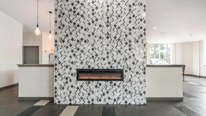 A modern lobby with a patterned wall, a fireplace, and a reception desk. - Quality Inn Rochester West (Rochester)