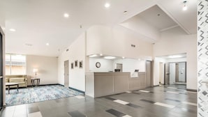 A spacious lobby with a reception desk, a sofa, and a patterned rug. - Quality Inn Rochester West (Rochester)