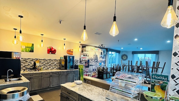 A modern kitchen with granite countertops, stainless steel appliances, and pendant lighting. - Quality Inn Rochester West (Rochester)
