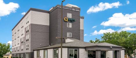 A hotel with a prominent 'Quality Inn' sign, a covered entrance, and a parking lot.