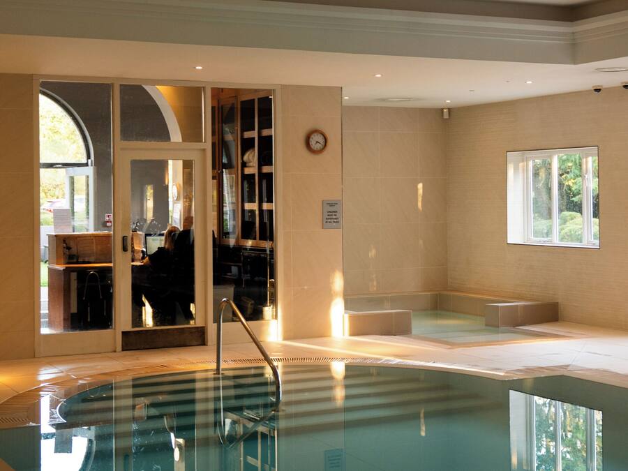 A swimming pool with a clear view of the adjacent room, a window, and a door leading outside.