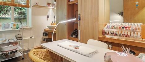 Quarto limpo e moderno com uma mesa branca, cadeiras de vime e um armário de madeira com diversos objetos.